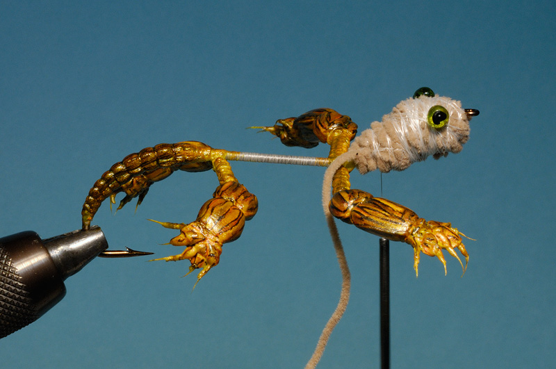 The head is shaped with a long strip of chenille. A plastic strip was pulled through the head with a needle, glass beads slid down, plastic melted until it was flush with the beads.