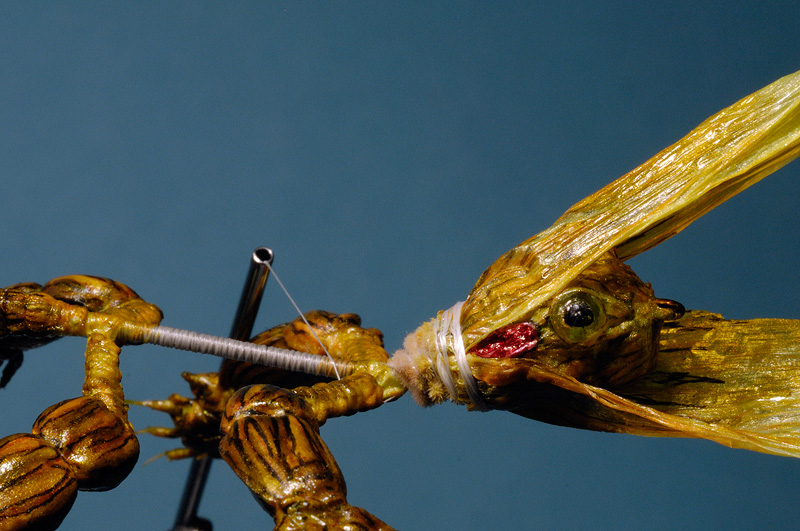 Raffia is colored with micron markers, pulled forward, and secured
